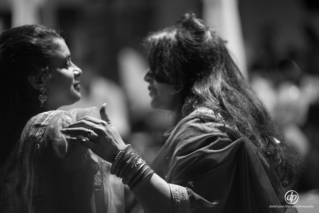 Black and white photo of guests at an Indian wedding celebration.