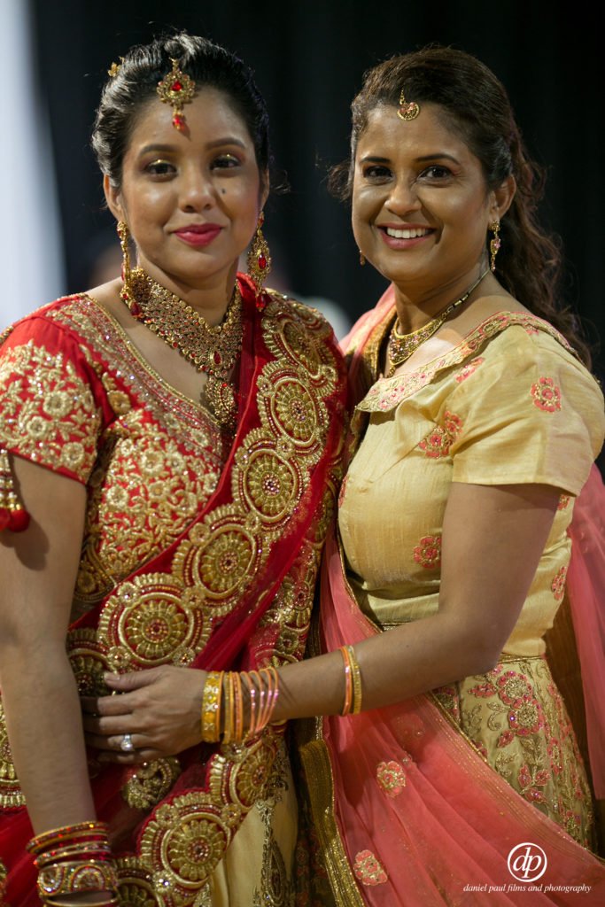 An Indian couple wearing traditional Indian attire celebrating at a wedding.